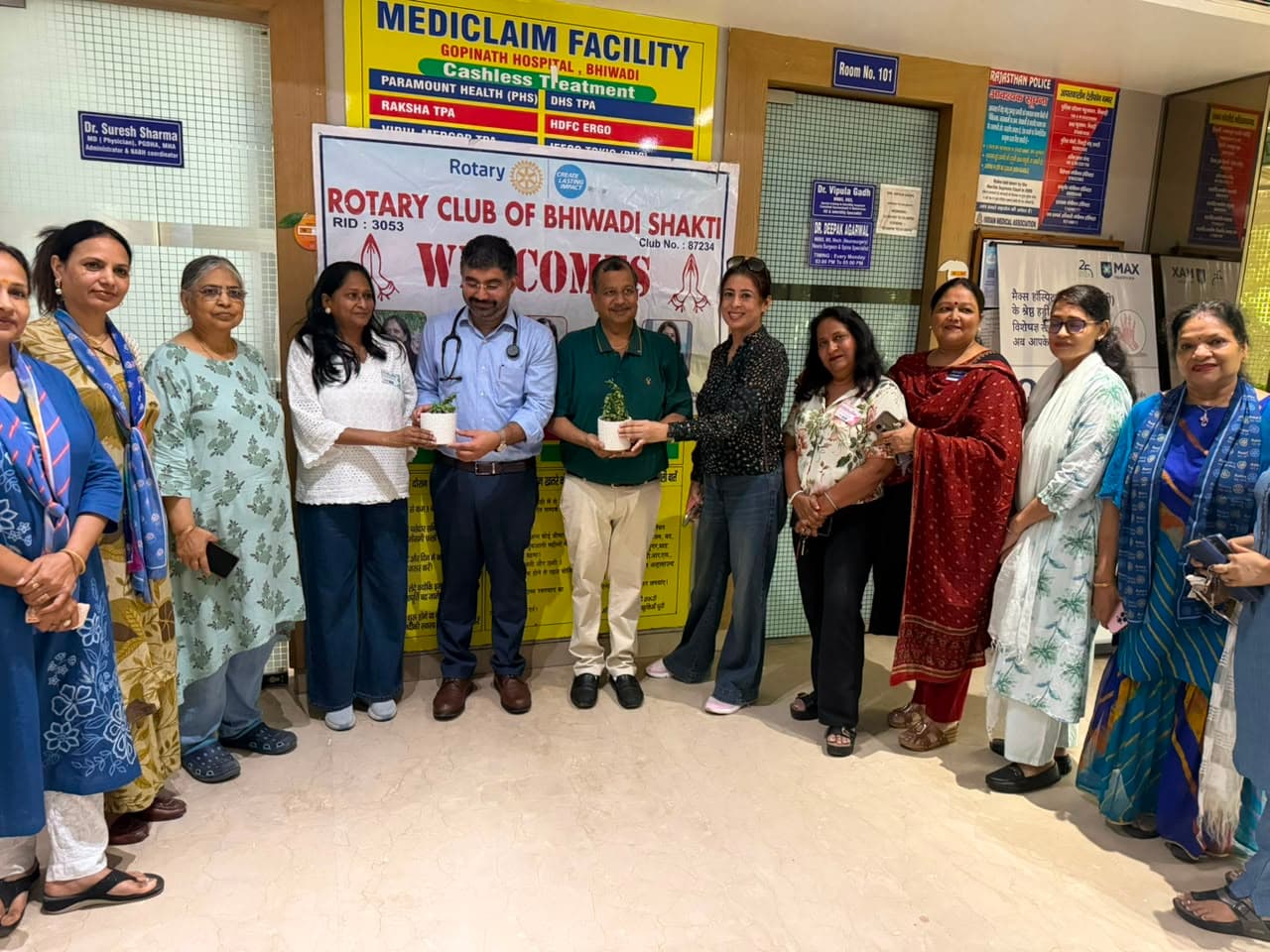 Rotary and Gopinath Hospital team members holding potted plants during a community event